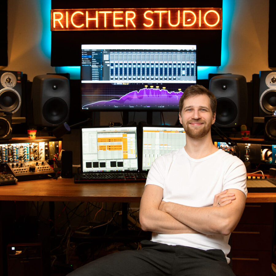 Professional portrait of an audio engineer in Richter Studio, featuring a modern mixing console, high-end audio gear, and dual monitors.