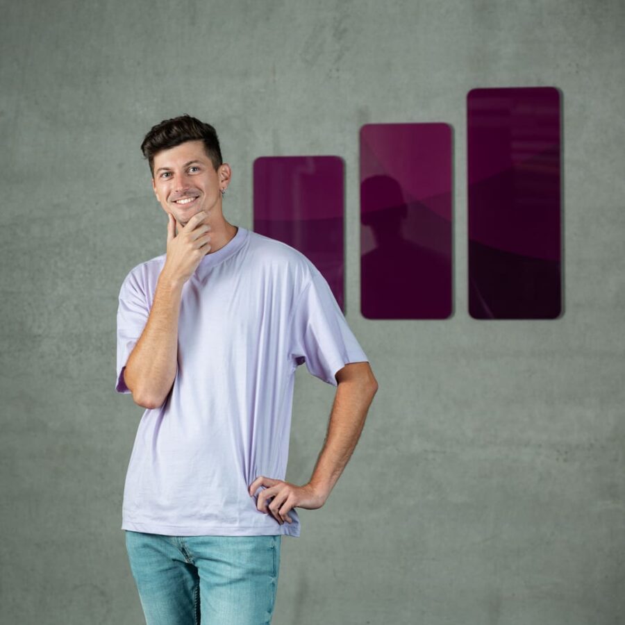 Portrait of a young professional in casual attire, standing by a concrete wall with AdCash logo, symbolising growth and creativity.