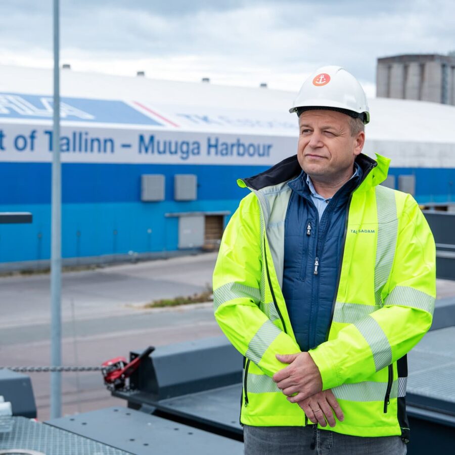 Operations manager at Muuga Harbour in high-visibility jacket and hard hat, standing with Port of Tallinn signage in the background.